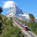 a train traveling past a snow covered mountain