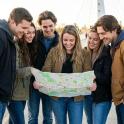 a group of people standing together holding a map