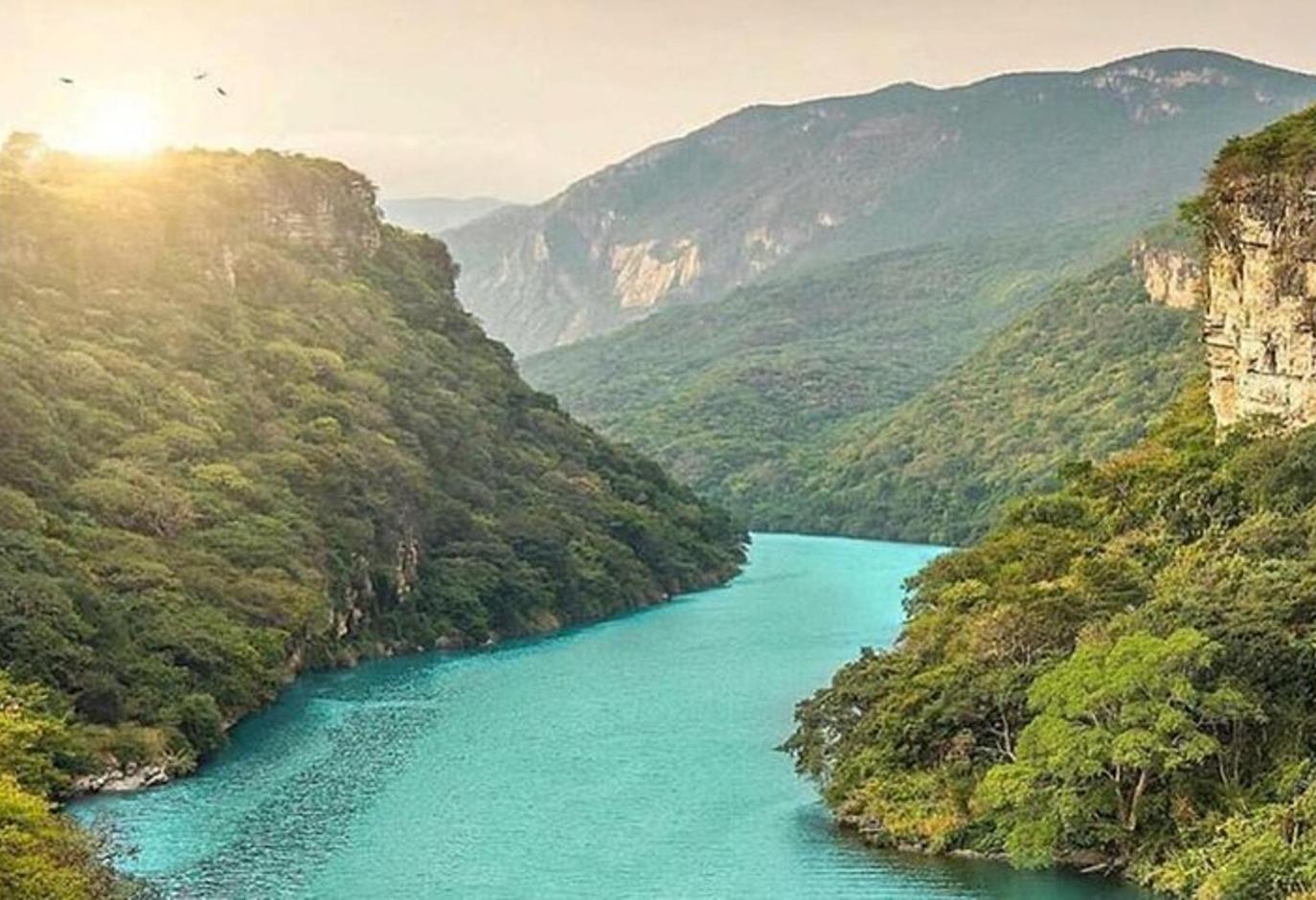 un río en medio de un valle con montañas