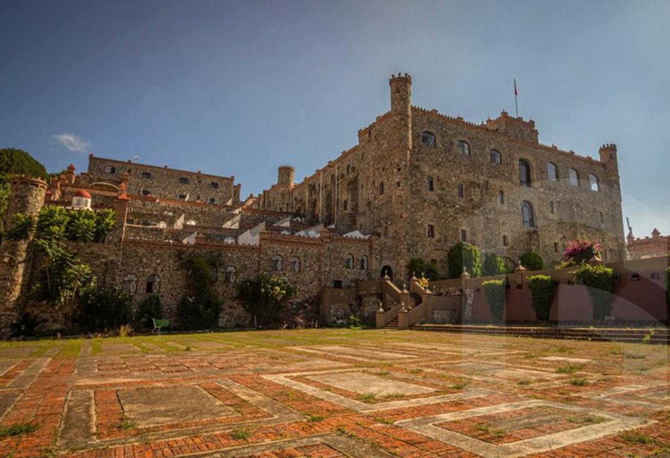 a large castle with a stone courtyard in front of it