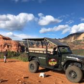 一辆绿色吉普车停在沙漠的一条土路上