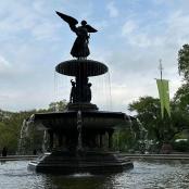 a statue of an angel sitting on top of a fountain