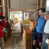 a woman taking a picture of two men in a warehouse