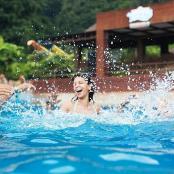 três pessoas brincando na água de uma piscina