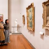 people standing in an art museum looking at paintings