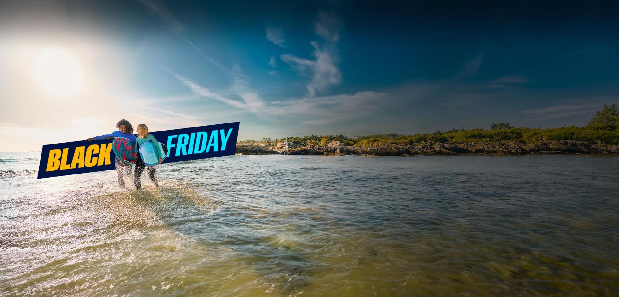 شعار بلاك فرايدي وشخصان على الشاطئ يحملان لوحين قصيرين لركوب الأمواج