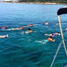 eine Gruppe von Menschen, die auf einem Boot im Wasser schwimmen