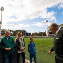 a group of people standing in front of a soccer field