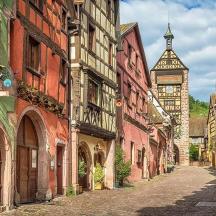 an alley in an old town with a clock tower