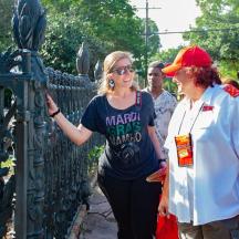 a woman is standing next to a metal fence