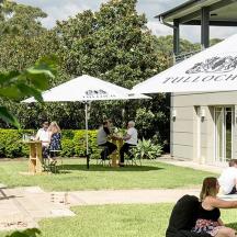 a group of people sitting in the grass with umbrellas