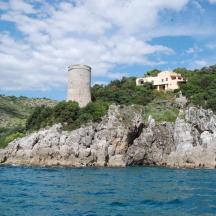 a house on top of a rocky island in the water