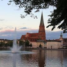 a city with a fountain in the middle of a lake