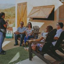un grup de persones assegudes en cadires parlant amb una dona