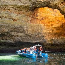 a group of people on a raft in front of a cave