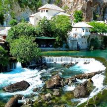 un riu amb una cascada i edificis al fons