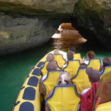 eine Gruppe von Menschen, die auf einem Floß in einer Höhle fahren