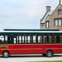 a red and green bus parked in front of a house