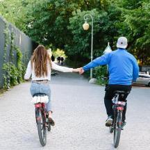 a man and a woman riding bikes down a street
