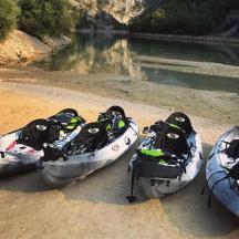 three canoes sitting on the shore of a river