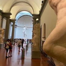 a group of people walking through a museum with statues