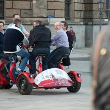 a group of people riding on a small scooter
