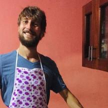 a man standing in a kitchen wearing a apron