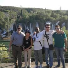 un grup de persones posant per a una foto davant d'una cascada