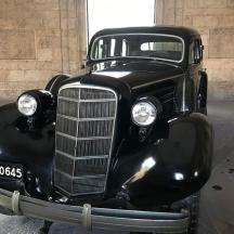 an old black car is on display in a building