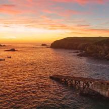 un tramonto su uno specchio d'acqua con un molo