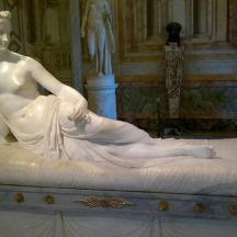 una estàtua d'una dona asseguda en un llit