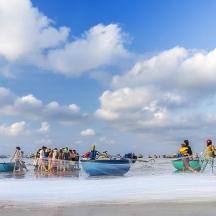 a group of people on a beach with boats
