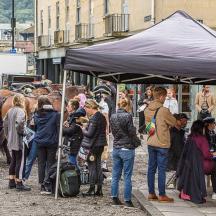 a crowd of people standing under a tent with a horse