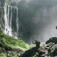 dues persones dempeus sobre roques prop d'una cascada