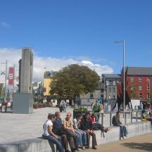 a group of people sitting on a bench in a city