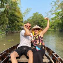 a man and woman sitting on a boat on a river