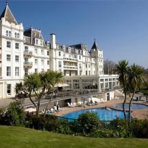 a large white building with a pool in front of it