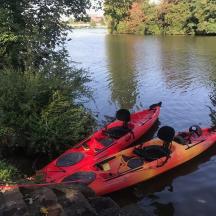 Un kayak rojo sentado al costado de un río