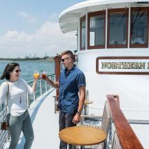 a man and woman drinking orange juice on a boat