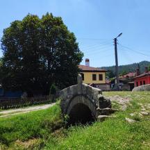 a small bridge over a road in a village