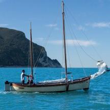 a man standing on a sail boat in the water