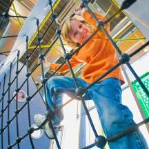 a young boy sitting on a playground ride