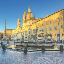a fountain in the middle of a street with buildings
