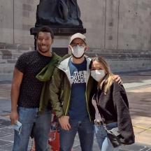 a man and a woman wearing masks in front of a statue