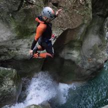 un home està saltant per sobre d'una cascada en un riu