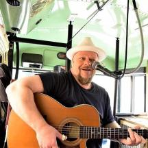 a man playing a guitar in a bus