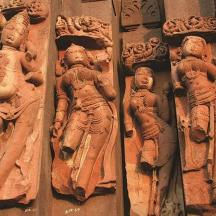a stone wall with statues of people on it