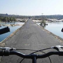 a bike is parked on a road next to water
