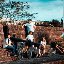 a group of people sitting on a brick wall with bikes