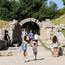 un gruppo di persone che camminano attraverso un tunnel di pietra